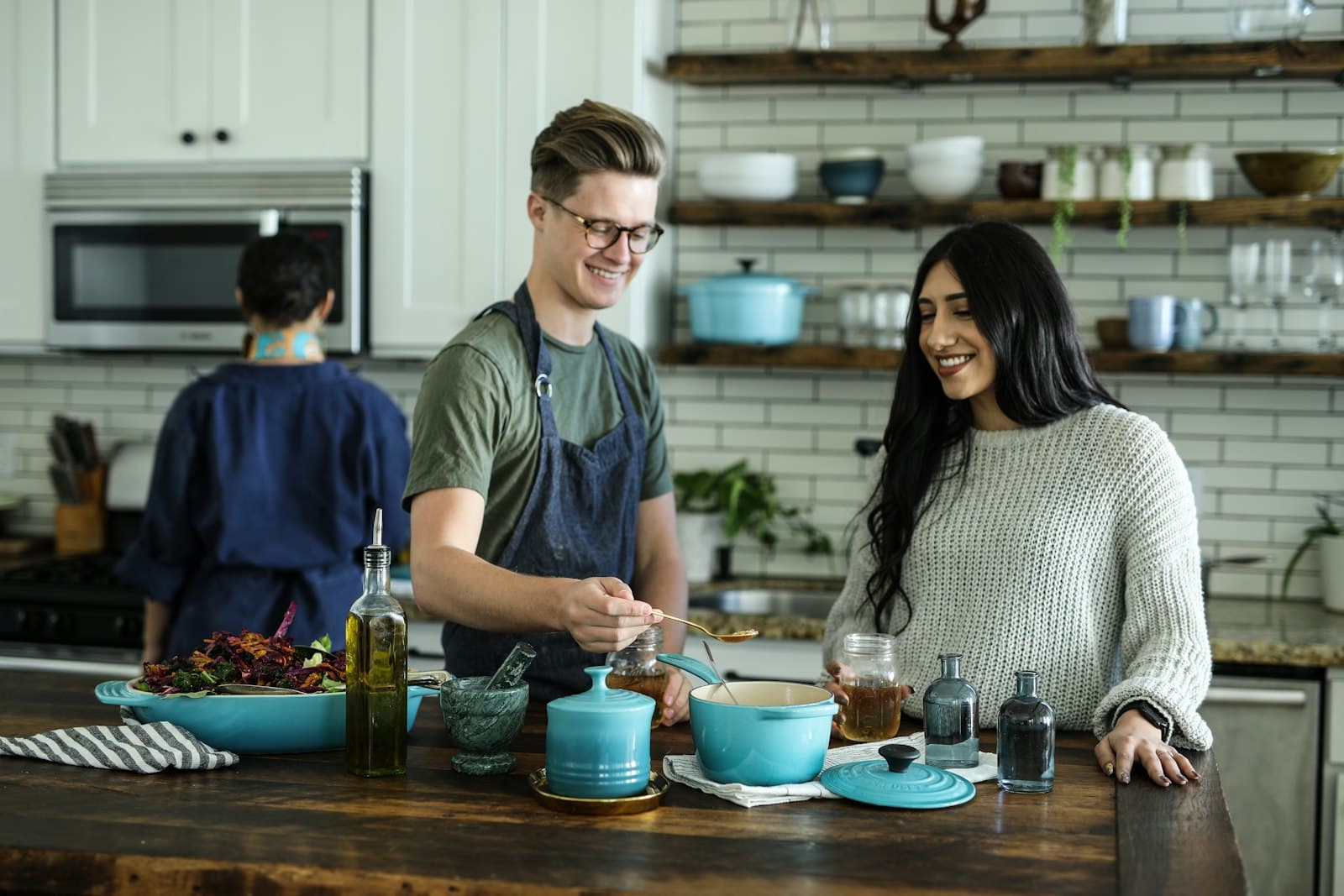 Friends laughing while cooking together in a home kitchen