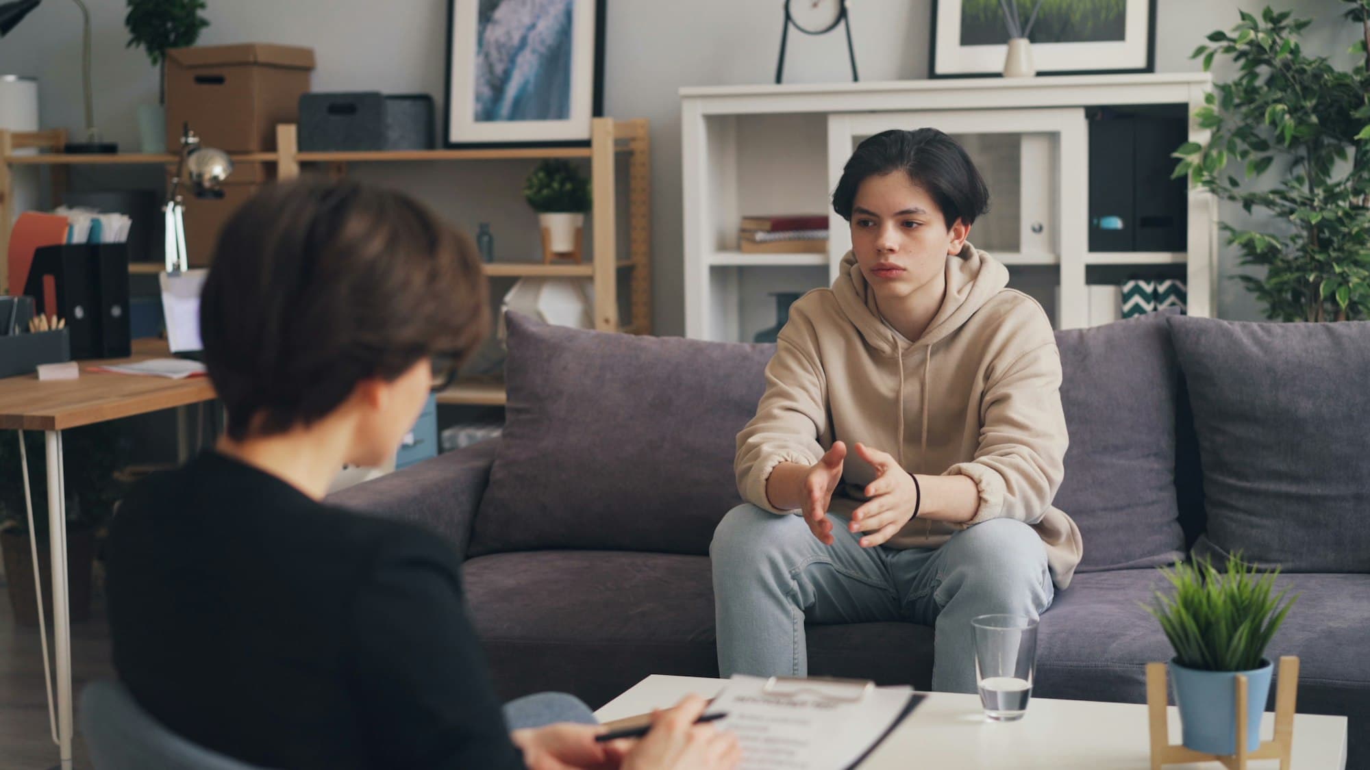 A young person talking calmly with a support worker who is taking notes
